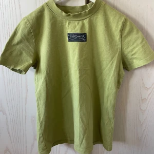 Ljusgrön t-shirt från EXIE - Säljer en ljusgrön t-shirt från EXIE med en liten svartvit logga på bröstet. T-shirten har rund halsringning och korta ärmar. Sitter som en storlek S