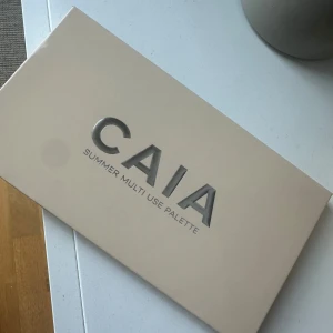 CAIA Summer Multi Use Palette - Snygg ansiktspalett från CAIA med åtta nyanser: matta och skimrande bronzers, matta och skimrande rouge i rosa toner, två highlighters (en ljus och en guldig), samt en matt chokladbrun och en ljus beige för contour eller setting. Perfekt för att skapa en fräsch somrig look.