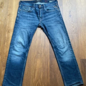 Replay Newbill jeans blå W30 - Säljer ett par Replay Newbill jeans i klassisk blå tvätt med snygga detaljer och raka ben. Jeansen har en normal passform. Perfekta för dig som gillar en tidlös denimlook. Längd 93 cm, bredd 41 cm. Skickar oftast samma dag!