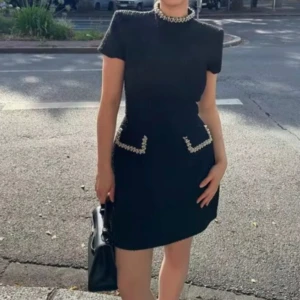 Svart klänning med pärldetaljer -  Säljer denna eleganta svarta klänningen. Perfekt för festliga tillfällen såsom Jul. Klänningen är aldrig använd och i storlek M. 🥰✨