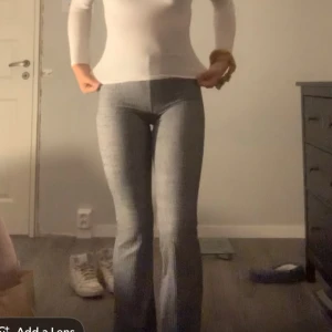 Grå ribbade bootcut byxor - Säljer ett par grå ribbade byxor med bootcut och hög midja. De är stretchiga och sitter tajt upptill med utsvängda ben. Perfekta för dig som gillar en bekväm men ändå trendig look. Materialet är mjukt och passar året runt.