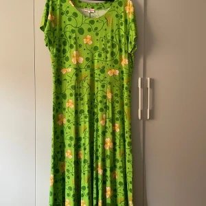 Grön blommig midiklänning Cissi och Selma - Superfin midiklänning från Cissi och Selma i modellen Hedvig. Klänningen är grön med blommigt mönster i gult och vitt, har rund halsringning och korta ärmar. Tillverkad i mjuk och stretchig ecovero viskos med elastan för extra komfort.