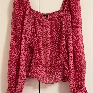 Rosa leopardmönstrad blus från Amelie - Säljer en luftig och transparent blus från Amelie i rosa med leopardmönster. Blusen har långa ärmar, resår vid axlar och midja samt en lös passform. Andvänt 2-3 gånger alltså är den i jätte bra skick! 