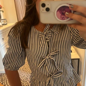 Randig blus - Populär blus från stradivarius som är blå vit randig med rosetter! 