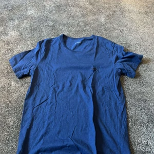 Blå t-shirt från BOSS i bomull - Snygg blå t-shirt från BOSS med broderad logga på bröstet. Klassisk rund halsringning och korta ärmar. Tillverkad i mjuk bomull som känns skön mot huden. Perfekt för en clean och stilren look.