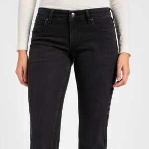 Svarta lowwaist bootcut jeans från Lee - Snygga svarta jeans från Lee med klassisk femficksdesign och knappgylf. Jeansen har en rak passform och normal midja, perfekta till sneakers eller boots. Materialet är mjukt och stretchigt för extra komfort. Modell jessica. Storlek W25 L31. Köpt för 1099kr