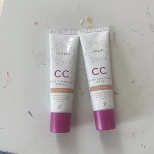 Lumene CC Cream Medium SPF 20 - Två tuber Lumene CC Color Correcting Cream i nyansen Medium. Ger jämn hudton med medium täckning och innehåller SPF 20. Passar alla hudtyper och är vegansk. Förpackningarna är vita med lila detaljer och guldtext.