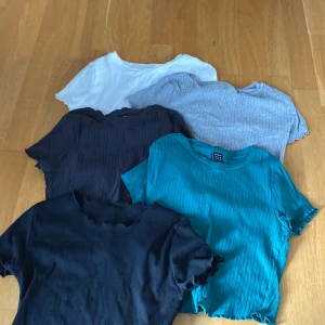 Fem ribbade toppar från SHEIN, S - Fem ribbade toppar från SHEIN i storlek S. Färgerna är vit, grå, svart, mörkblå och turkos. Alla har kort ärm, rund hals och en slim passform. Perfekta att matcha med jeans eller kjol för en enkel och snygg look.