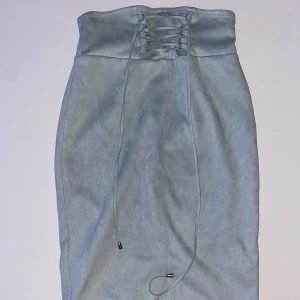 Grå kjol från Forever 21 - Snygg grå kjol från Forever 21 med snörning i midjan. Kjolen har en stilren design och är perfekt för att skapa en chic look. Tillverkad i ett mjukt material som ger en bekväm passform.