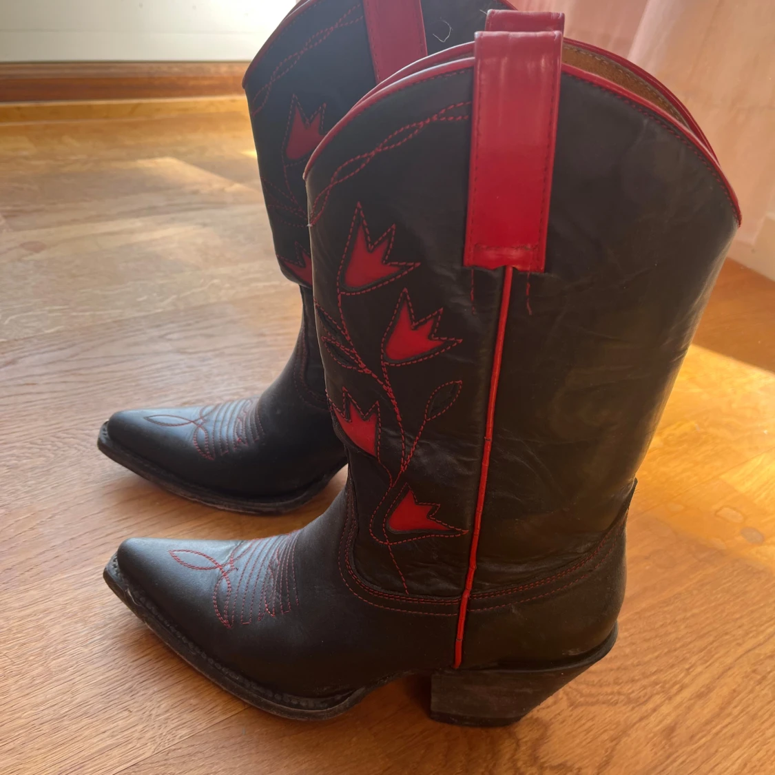 Svarta cowboy boots med röda detaljer