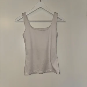 Beige linnetopp Zara - Säljer en stilren beige linnetopp med breda axelband. Perfekt för varma dagar eller som ett basplagg i garderoben. Enkel och tidlös design som passar till det mesta.