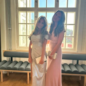 Glittrig axelbandslös klänning - Säljer en fantastisk glittrig klänning i silver med axelbandslös design och en elegant slits. Perfekt för en glamorös kväll!