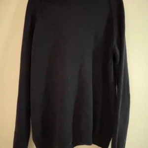 Svart polotröja från Oscar Jacobson - Snygg svart polotröja från Oscar Jacobson i storlek S. Perfekt för kyligare dagar med sin stilrena design och långa ärmar. Aldrig använd. 