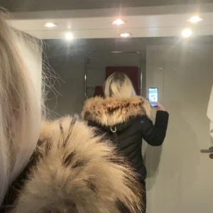 Svart dunjacka med äkta päls från Hollies (nyskick) - Äkta Hollies vinterjacka Svart, stl 36 Inköpt dec 2018 i Stockholm  Max använd 1 gång - nyskick Ingen prislapp/kvitto, men är 100% äkta (etiketter + logga finns) Guldiga dragkedjor + pälsfodrad huva Mitt pris: 4200kr