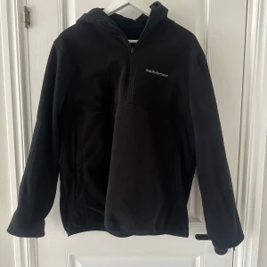 Svart fleecejacka från Peak Performance - Säljer en svart fleecejacka från Peak Performance med dragkedja och huva. Jackan har en stilren design med broderad logga på bröstet. Perfekt för kyliga dagar. Storlek står ej men skulle gissa på en M.