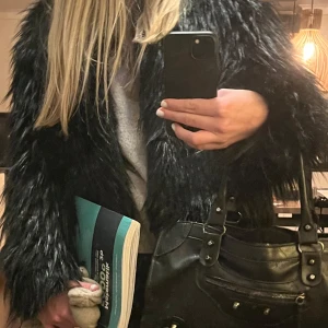 Svart pälsjacka - Snygg svart pälsjacka med långärmad design. Jackan har en modern look och passar bra till olika outfits. 🩷 
