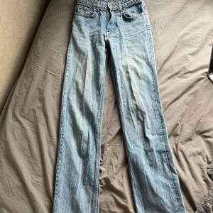 Blå jeans från Zara - Snygga blå jeans från Zara med en klassisk straight fit. De är midwaist/highwaist och har en stilren design med fickor och knappgylf. Perfekta för en avslappnad look. Det finns en liten defekt som man kan se på sista bilden men inget som syns tydligt alls. De är i storlek 34 och skulle säga att de passar de med xs/s och om någon är intresserad skickar jag gärna mått eller svarar på andra frågor. Är öppen för nya prisförslag 💕