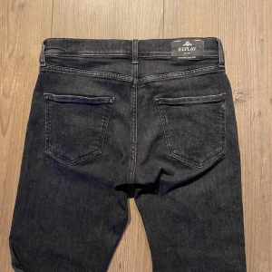 Svarta jeans från Replay - Snygga svarta jeans från Replay med klassisk femficksdesign. De har en slim fit passform och är perfekta för en stilren look. Tillverkade i ett slitstarkt material som ger en bekväm känsla hela dagen.