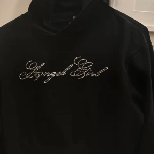 Croppad hoodie med strass  - Snygg svart hoodie med texten 'Angel Girl' i glittriga stenar på framsidan. Tröjan är croppad. Se mina andra annonser med billiga kläder & väskor 🤍