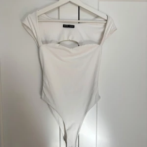 Vit bodysuit - Snygg vit bodysuit med korta ärmar och en öppen ryggdetalj. Endast använd ett fåtal gånger, sista bilderna är lånade då jag själv inte har någon bild med dem på🩷