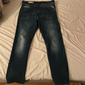 Blå jeans från Replay - Snygga blå jeans från Replay, modell Grover. De har en klassisk femficksdesign med dragkedja och knapp. Perfekta för en avslappnad stil. Priset är pågrund av att jag ej använder de.
