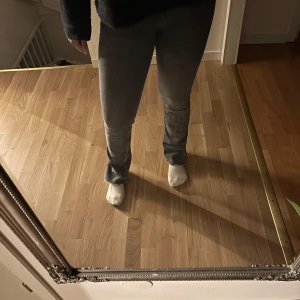 Grå jeans med slits - Snygga grå jeans med en rak passform och hög midja och slits vid anklarna. Perfekta för en avslappnad stil. Jeansen är från Zara i storlek 38 .