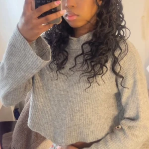 Grå ribbad croppad tröja - Säljer en stilren grå ribbad tröja med croppad passform. Tröjan har långa ärmar och är perfekt för en avslappnad look. Passar bra till både jeans och kjol.