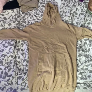Beige hoodie med magficka - Säljer en beige hoodie från Etab. 1999 i storlek 150. Tröjan har en klassisk huva och en stor magficka framtill. Perfekt för en avslappnad stil och enkel att matcha med det mesta.