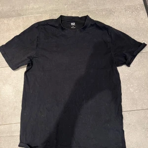 Svart t-shirt från 157 - En klassisk svart t-shirt från 157 med rund hals och lite längre  ärmar. Enkel och stilren design som passar till det mesta. Tillverkad i mjukt material för en bekväm känsla.