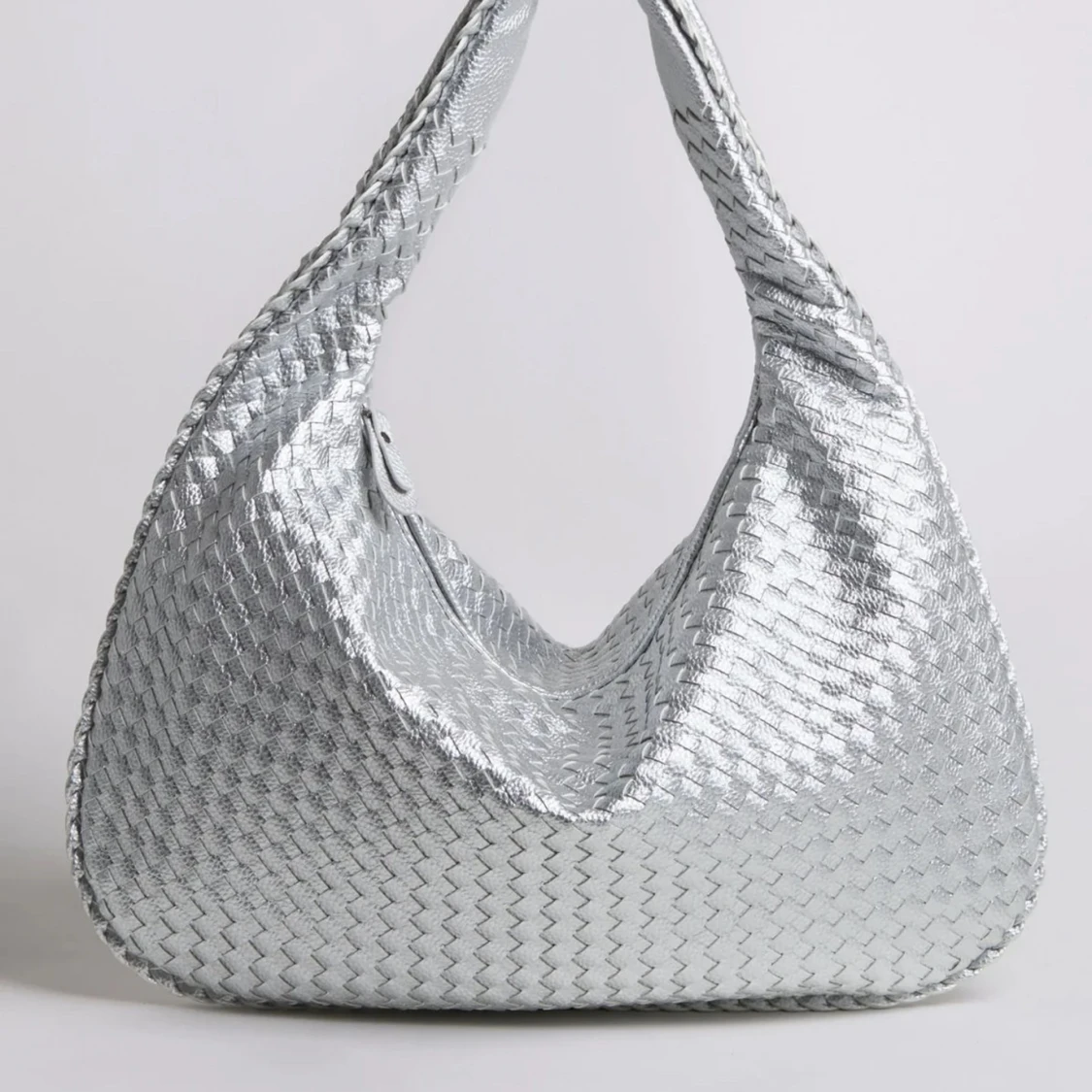 Silvrig axelväska med flätad struktur
