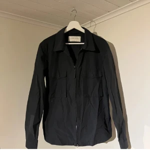 Svart Overshirt med dragkedja - A Day’s March  - Säljer denna sjukt snygga Overshirten från A Days March⭐️ Färgen är svart och storleken är S✅Jackan har inga defekter och skicket är utomordentligt🙌🤝 Sjukt najs passform och passar perfekt som vår och sommarjacka☀️🙌 Tveka inte på att höra av er dig vid minsta fråga eller fundering😊