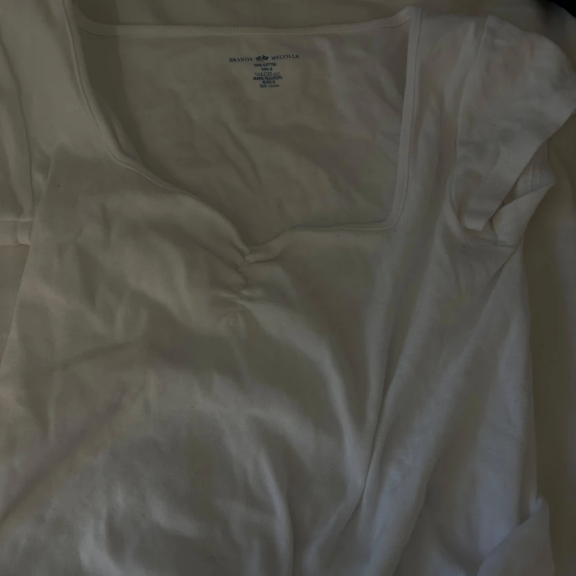 Vit topp med rynkdetalj från Brandy Melville