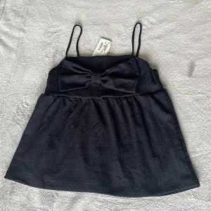 Mörkblå topp med rosett från Kappahl - Säljer en gullig topp med rosett på💕 helt ny, Orginal pris 250 