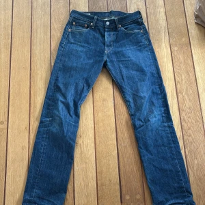 Levi's 501 blå jeans - Klassiska blå Levi's 501 jeans med raka ben och femficksmodell. Byxorna har knappgylf och tydliga kontrastsömmar. Passar dig som gillar tidlös denimstil och vill ha ett par jeans som funkar till det mesta.