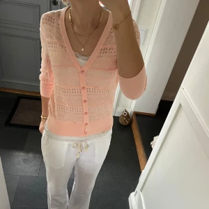 Rosa stickad kofta  - Rosa trekvartsärmad mönstrad kofta från Yumi i storlek M, passar även S. Fint skick. Använd gärna köp nu!