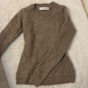 Beige kashmirtröja från FTC - Mysig beige kabelstickad tröja i 100%  kashmir från FTC. Klassisk rund halsringning och långa ärmar. Perfekt för hösten, Den är även tight i midjan som då ger en snatched look. Köpt för 1500kr och säljer för 699kr