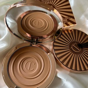Charlotte Tilbury bronzer - Superfin bronzer i nyansen Medium från Charlotte Tilbury. Den heter Charlotte Tilbury Beautiful Skin Sun-Kissed Glow Bronzer Medium. Använd tre gånger men vill ha den i en mörkare färg. Den är fräsch och väldigt fin formula och ääälskar dosan!! (Första bilden är lånad) hör av dig vid frågor. Ordinarie pris är 650kr