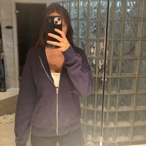 Mörkblå hoodie med dragkedja från Stradivarius - Säljer en mörkblå hoodie från Stradivarius i storlek S. Jackan har huva, dragkedja framtill och två fickor. 