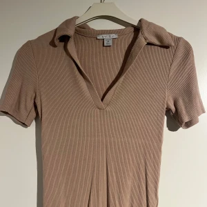 Ribbad tröja med krage  - Säljer en beige ribbad tröja med krage och v-ringning. Stretchigt tyg 