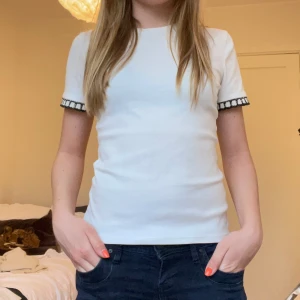 Vit topp med detaljer från zara - Säljer en vit topp med korta ärmar och fina detaljer vid ärmarna från zara i storlek S. 