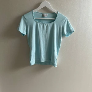 Ljusblå tight T-shirt  - Säljer en ljusblå t-shirt från hm. Den är en tightare modell men är i super mjukt tyg. Toppen är i mjuk bomull och har en enkel, stilren design som passar perfekt till sommaren💗💗