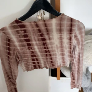 Brun- och beige batikmönstrade leggings - Säljer ett par stretchiga leggings med batikmönster i bruna och beige toner. Byxorna har en tight passform och är perfekta för dig som gillar en unik och trendig stil.