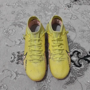 Gula Nike fotbollsskor med snörning - Säljer ett par gula Nike fotbollsskor med svarta detaljer och snörning. Skorna har en platt sula med dobbar i vitt och rosa undertill, perfekt för spel på gräs. Lätta och smidiga med klassisk Nike-logga på sidan. Pris kan diskuteras. Frågor och sånt kan ni bara skriva 