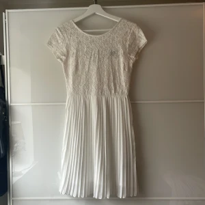 Vit spetsklänning med plisserad kjol - Superfin vit klänning med spets upptill och plisserad kjol. Perfekt till sommaren, studenten eller konfirmationen. Från Gina Tricot. Mycket bra skick. 