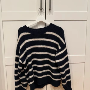 Svart och vit randig stickad tröja - Mysig stickad tröja med svarta och vita ränder. Tröjan har rund halsringning och långa ärmar. Perfekt för kyligare dagar🫶🏼🫶🏼