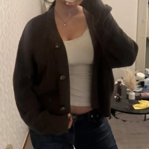 Stickad kofta med knappar - Brun stickad kofta med stora knappar framtill. Koftan har en avslappnad passform och långa ärmar 🤎