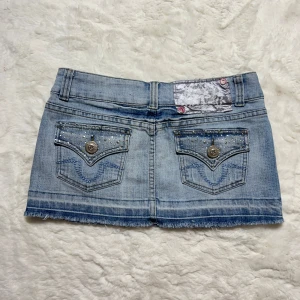 Lågmidjad jeanskjol / minikjol vintage 2000s - Mini jeanskjol med fina detaljer. Stolek 8, motsvarar xs-s. Midjemått:37. Köp sker via köp nu, jag postar inom 24h. Kvar tills markerad såld 