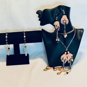 Set med pärlörhängen, halsband och armband - Unikt smyckeset med stora handgjorda örhängen, halsband och armband. Smyckena har pärlor i ljusrosa, svart, guld och vit, med detaljer i metallkedjor och hängande pärlor. Designen är maxad och färgstark, perfekt ska hämtas vid dörren 