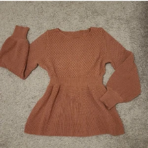 Topp - Helt ny, aldrig använd stickad tröja. Tröjan har en peplumdesign med långa ärmar och en rund halsringning. Köptes för 209 kr, men valde fel storlek 🫶