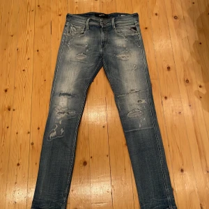 Replay Anbass blå skinny jeans - Snygga Replay Anbass jeans i blå tvätt med slitna detaljer och skinny passform. Klassisk femficksdesign, låg midja och dragkedja. Jeansen har coola slitningar och är gjorda i stretchigt denim för skön känsla. Perfekta för dig som gillar street och modern stil. Priset kan diskuteras